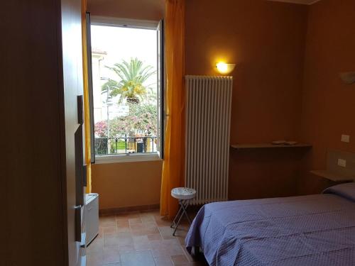 a bedroom with a bed and a window at Perla Nera Guesthouse in Imperia