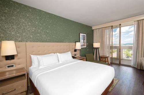 a bedroom with a white bed and a green wall at Hilton Birmingham Downtown at UAB in Birmingham