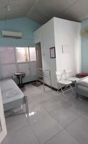 a room with two beds and chairs and a table at Benara Shariah Homestay in Yogyakarta