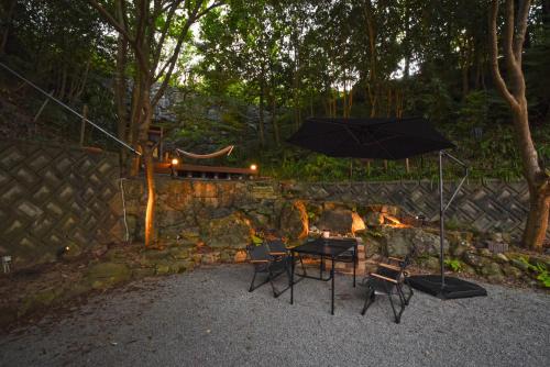 a patio with a table and chairs and an umbrella at 鈴音 by 4S STAY in Sanuki