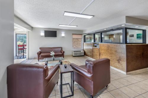 a living room with leather chairs and a table at Quality Inn Glasgow in Glasgow