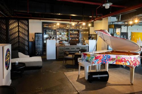 a room with a piano and a bar at The Apurva Kempinski Bali in Nusa Dua
