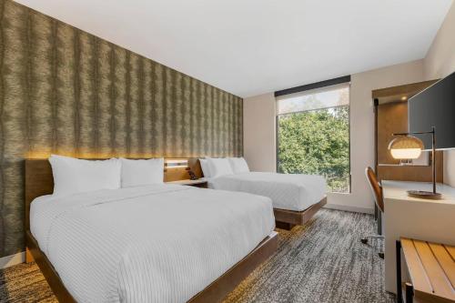 a hotel room with two beds and a window at Cambria Hotel Portland - Pearl District in Portland