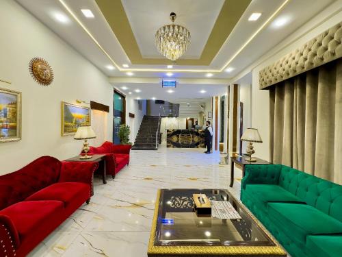 a living room with red and green couches at Shalimar Hotel in Multan