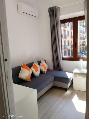 a blue couch in a room with a window at Home 120, Mansion Alhamar in Sitio de Calahonda