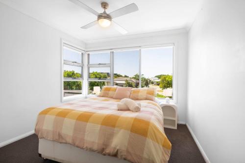 Un dormitorio blanco con una cama y una ventana. en Zen Garden - Serene Townhouse, en Gold Coast