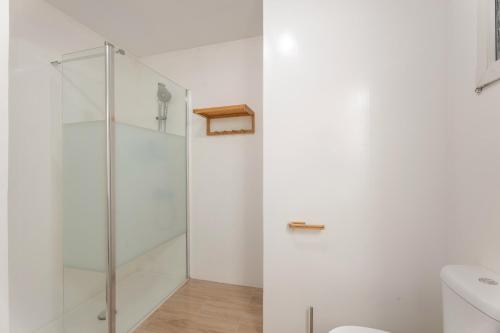 a white bathroom with a shower and a toilet at La Bahia in Santa Cruz de Tenerife