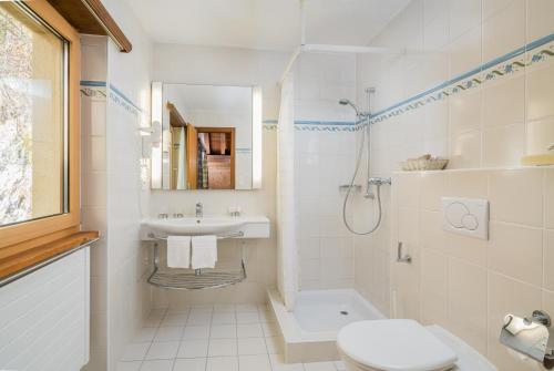 a bathroom with a sink and a toilet and a shower at Ferienwohnungen Seraina in Sils Maria