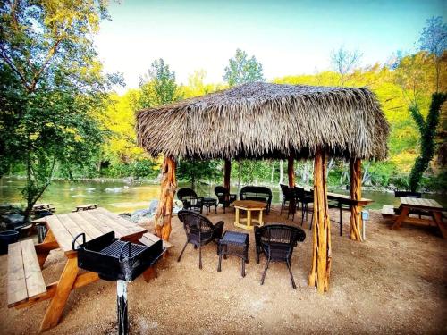 a pavilion with chairs and tables and a straw roof at Exciting Family Vacation with Kayaks, Canoes, and More: Comfortable Bell Tent near New Braunfels, Texas in Second Crossing