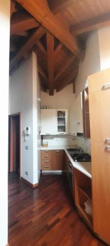 a large kitchen with wooden floors and wooden ceilings at CASA BEA Elegante mansarda vicina a Fiera in Pero