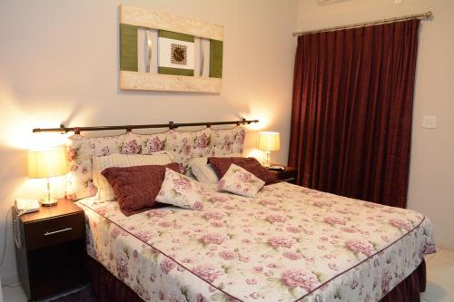 a bedroom with a large bed with flowers on it at Excellence Plaza Hotel in Botucatu