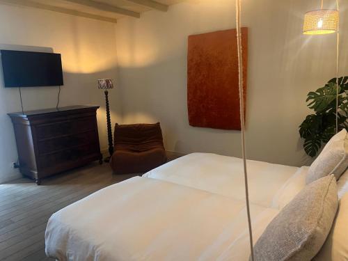 sypialnia z łóżkiem, krzesłem i telewizorem w obiekcie B&B Maryline w Antwerpii