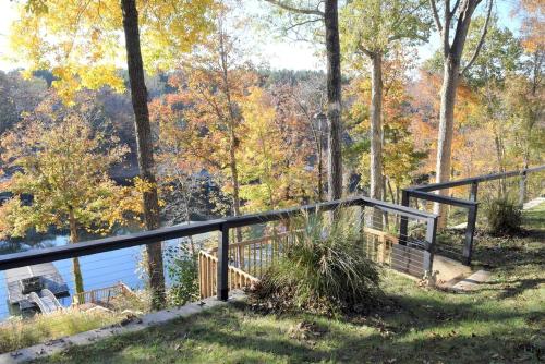 a wooden railing next to a body of water at Group Getaway by the Lake: Pet-Friendly Rental with Boat Dock in Picturesque Cullman County in Bremen