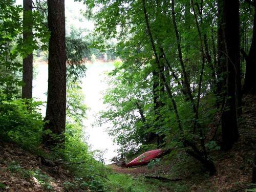 a red kayak in the woods next to a river at Stunning and Secluded Lakeside Getaway in the Grass Valley of California in Pinecrest