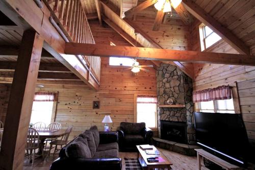 a living room with a couch and a fireplace at Spectacular Cabin Rental for Large Groups near New River in West Virginia in Hico