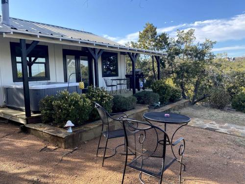 a table and chairs in front of a house at The Ultimate Romantic Getaway: Charming Cabin with a Hot Tub in Wimberley, Texas in Woodcreek