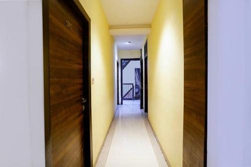 a hallway with a wooden door and a hallway with a floor at FabExpress New Silver Elite in Mumbai