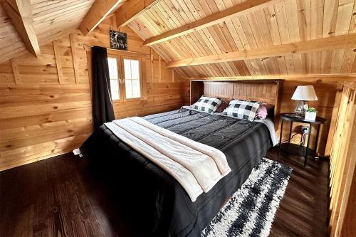 a bedroom with a bed in a wooden cabin at Romantic Lakefront Cabin with Mountain Views, Perfect for a Trip to Cantwell, Alaska in Cantwell