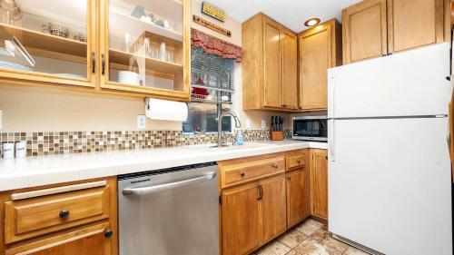 eine Küche mit Holzschränken und einem weißen Kühlschrank in der Unterkunft Charming Cabin for Winter and Water Sports Fans Near Big Bear Lake, California in Arrowbear Lake