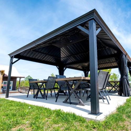 a picnic table and chairs under a black pavilion at Fantastic Secluded Tented Cabin with Fire Pit in Logan, Ohio in Logan