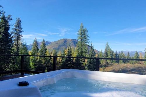 a hot tub with a view of a mountain at Mountain View Cabin with Deck, Jacuzzi and Ping Pong Table in Montana in West Glacier