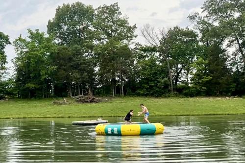 two people are standing on a raft in the water at Outstanding Lakefront Cabin in Makanda, Illinois in Sunset Harbor