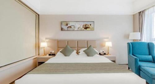 a bedroom with a bed and a blue chair at Hefei Parkview Hotel in Hefei