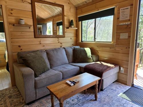 a living room with a couch and a coffee table at Incredible Modern Tiny Log Cabin near the Ammonoosuc River for a Romantic Getaway in New Hampshire in Jericho
