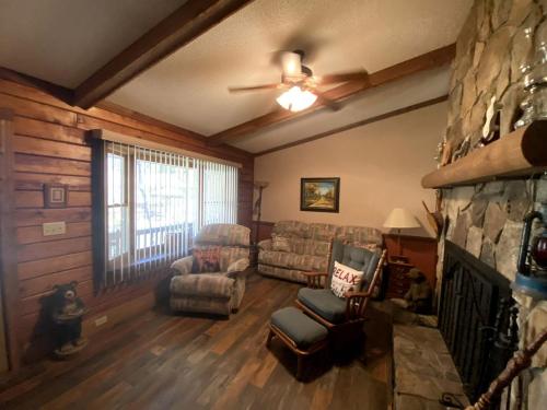 a living room with a couch and a fireplace at Rustic Log Cabin Rental near Chattahoochee National Forest, Georgia in Hiawassee