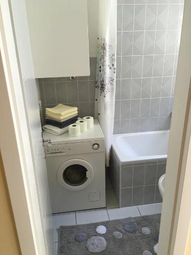 a bathroom with a washing machine and a bath tub at Apartment Satus in Podstrana