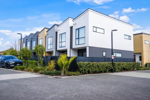 an apartment building with a car parked in a parking lot at Huntington Townhouse with Patio and Parking in Auckland