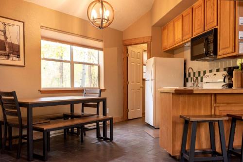a kitchen with a table and a refrigerator at Waterfront Camping Cabin near the Great Sand Dunes in Colorado in Monarch