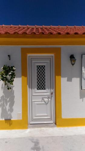a white door on a house with a red roof at Visitar Bioucas II - Casa Tradicional Familiar in Bioucas