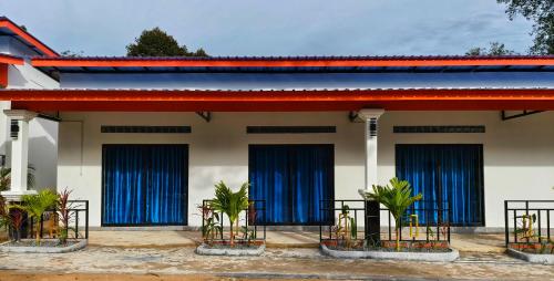 a house with blue curtains and plants in front of it at David Hostel in Koh Rong