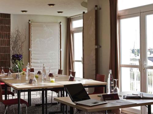 a meeting room with two tables with laptops on them at Mercure Port La Grande Motte in La Grande-Motte