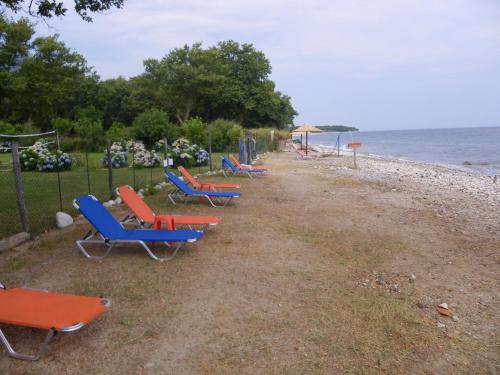 a row of chairs and tables on the beach at Archondissa Beach Aparthotel in Therma