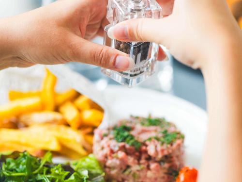a person holding a bottle of water next to a plate of food at Mercure Metz Centre in Metz