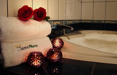 a bathroom with a towel with two roses and candles at Hotel Torre Norte in Trujillo