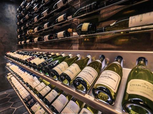a bunch of bottles of wine in a refrigerator at Mercure Dijon Centre Clemenceau in Dijon