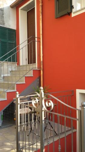 a red building with a staircase and a door at Agriturismo Nonni Devia in Lucinasco