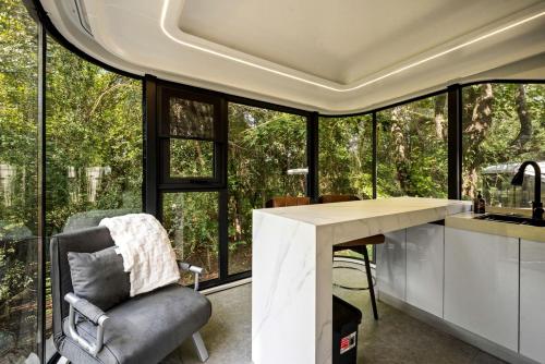 a kitchen with a desk and a chair in front of a window at Modern Airstream Glamping with Pond Views in Rural South Carolina in Saint Stephen