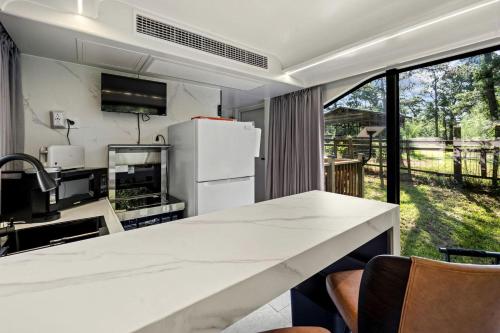 a kitchen with a white counter and a refrigerator at Modern Airstream Glamping with Pond Views in Rural South Carolina in Saint Stephen