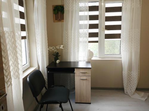 a desk and a chair in a room with a window at Lina Gio Apart in Karlovo