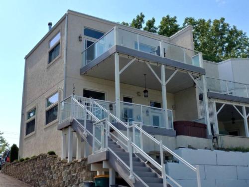 une maison avec un balcon et des escaliers en face de celle-ci dans l'établissement Incredible Waterfront Villa with Stunning Sights in Gary, Indiana, à Miller