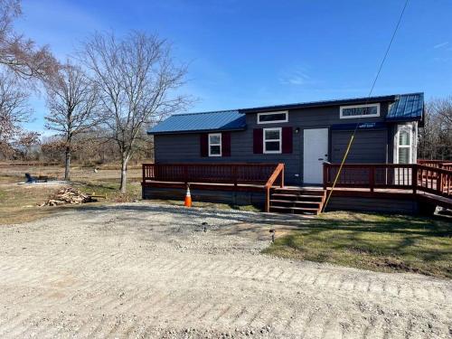 a blue house with a porch and a deck at Intimate Chic Cabin Suitable for Four with Private Deck in Texas in Emory