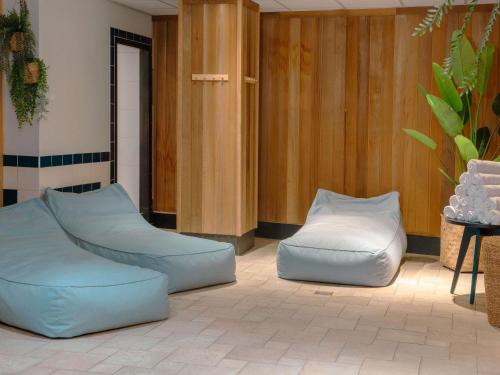 a living room with two blue and white chairs at Mercure Hotel Tilburg Centrum in Tilburg