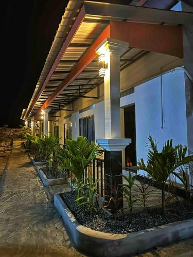 a building with a row of plants in front of it at David Hostel in Koh Rong