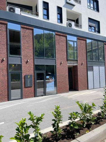a brick building with glass doors and windows at Breeze Stay Apartman in Bijelo Polje
