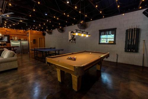 a pool table in a room with a ping pong ball at Spacious and Rustic Cabin with a Hot Tub near Copperhill for a Family Getaway in Tennessee in Copperhill