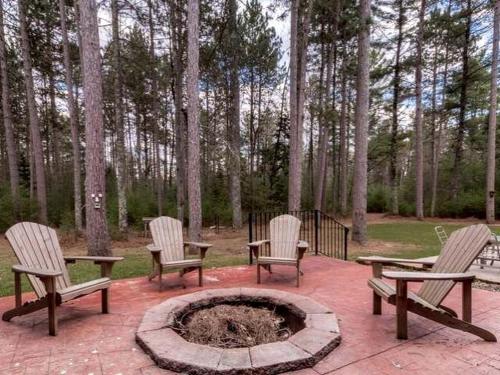a group of chairs and a fire pit in a park at Log Cabin Elegance: Your Private Haven on 5 Acres of Hazelhurst Waterfront in Hazelhurst